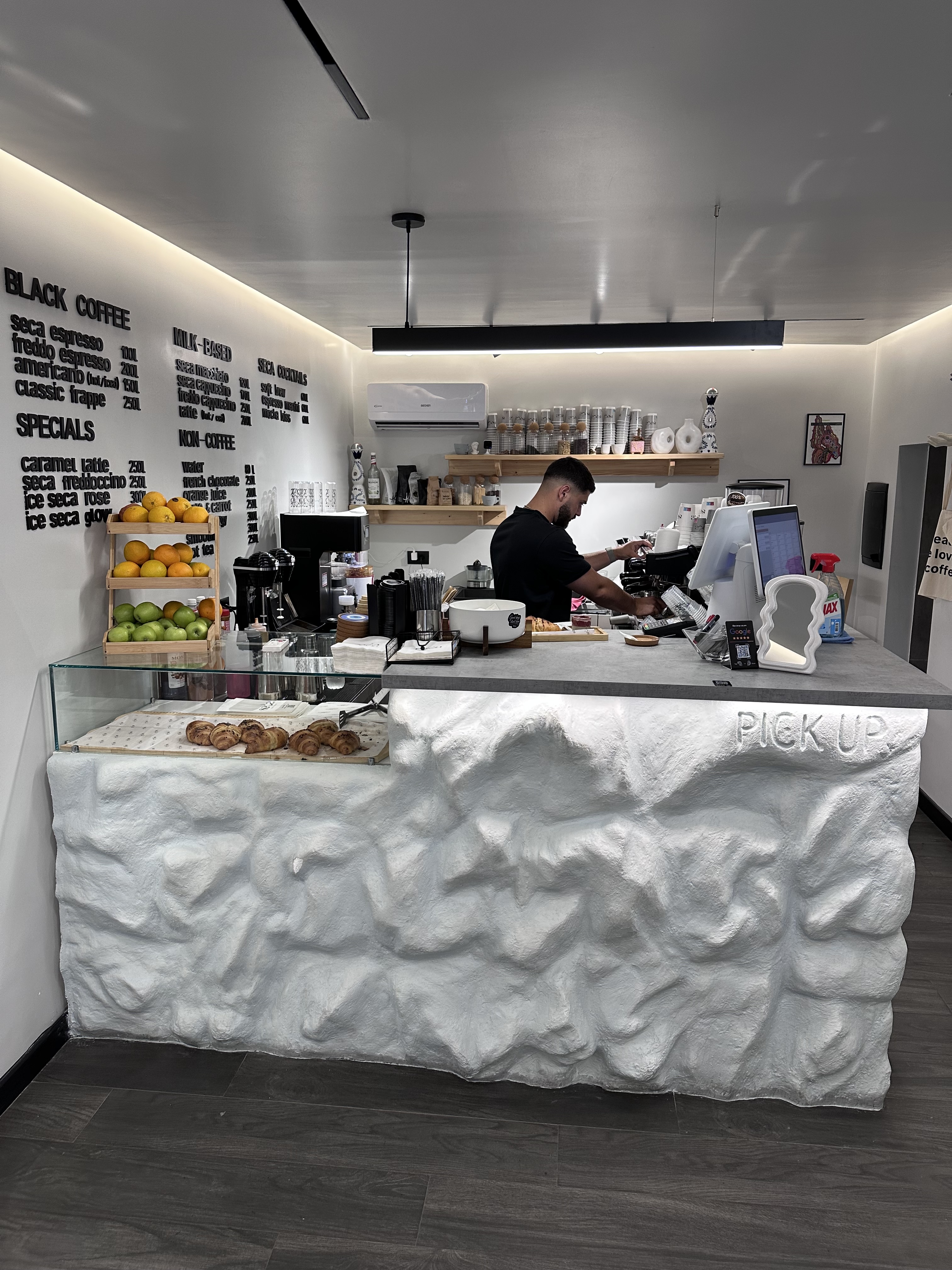 SECA COFFEE menu board and textured counter in Tirana
