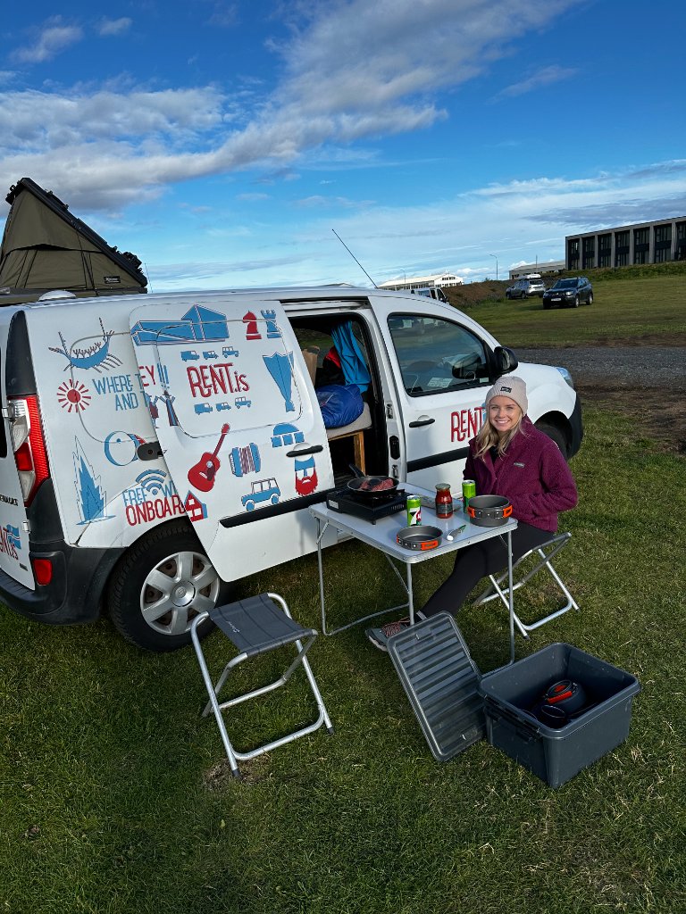 Our rental campervan parked in a grassy field in Iceland with the side door open