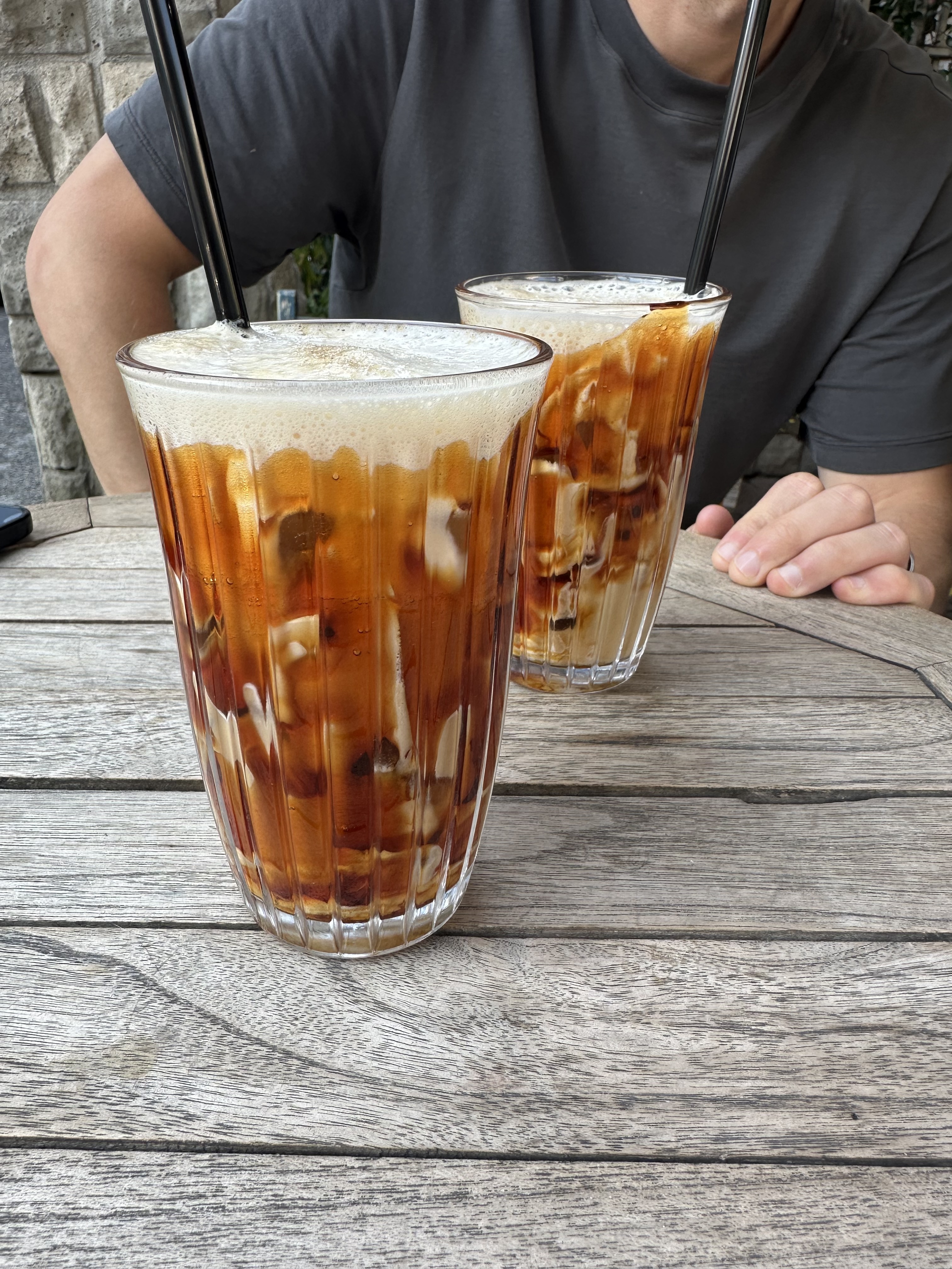 Two iced coffees served on a wooden table at a Tirana café