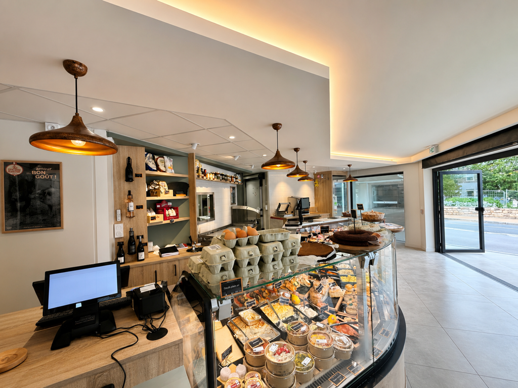 Intérieur de la Maison Blanchard à Trégastel, comptoir, vitrine réfrigérée et étagères en bois