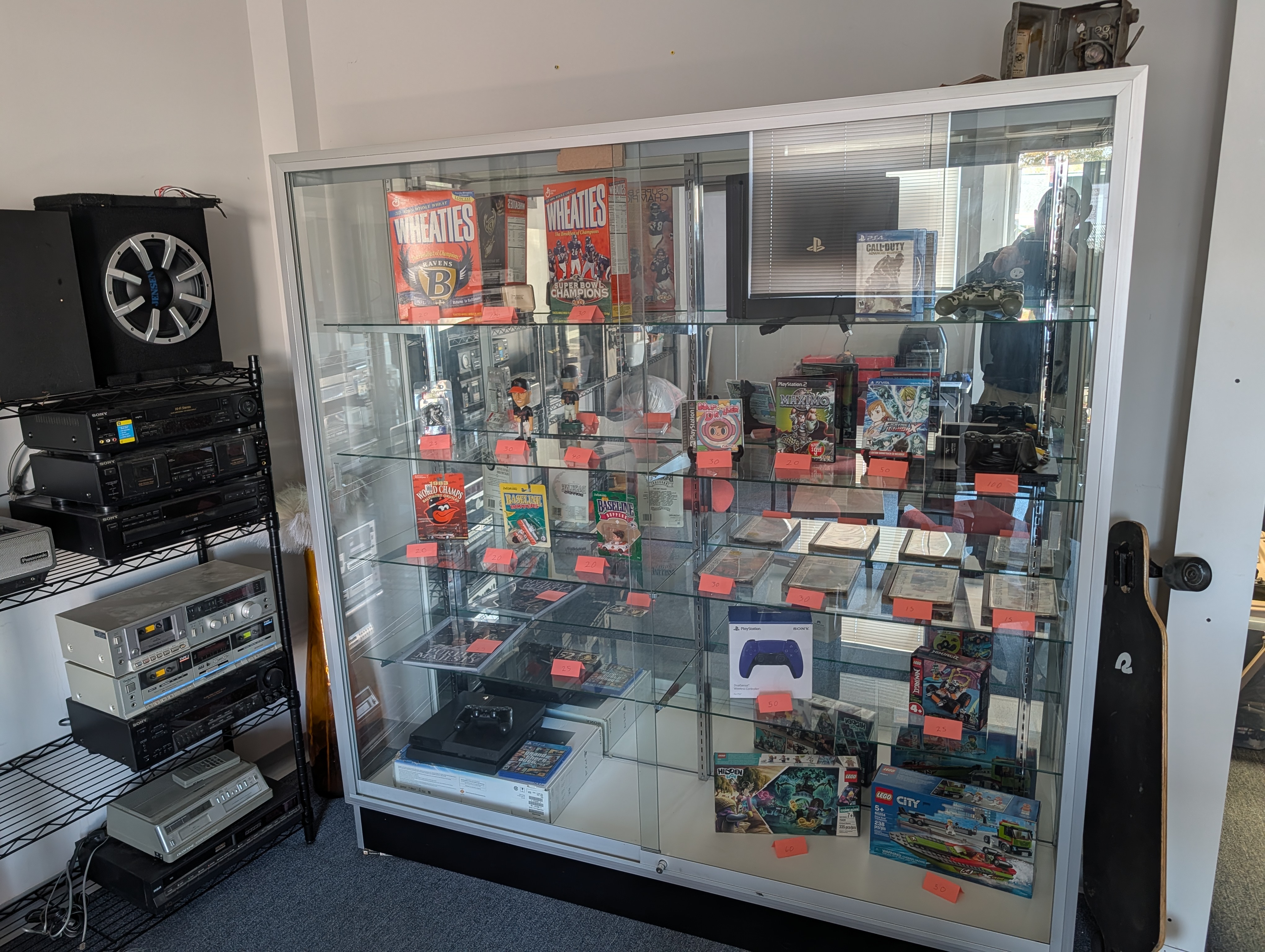 Display case of vintage video games, consoles, and collectibles inside Charm City Retro