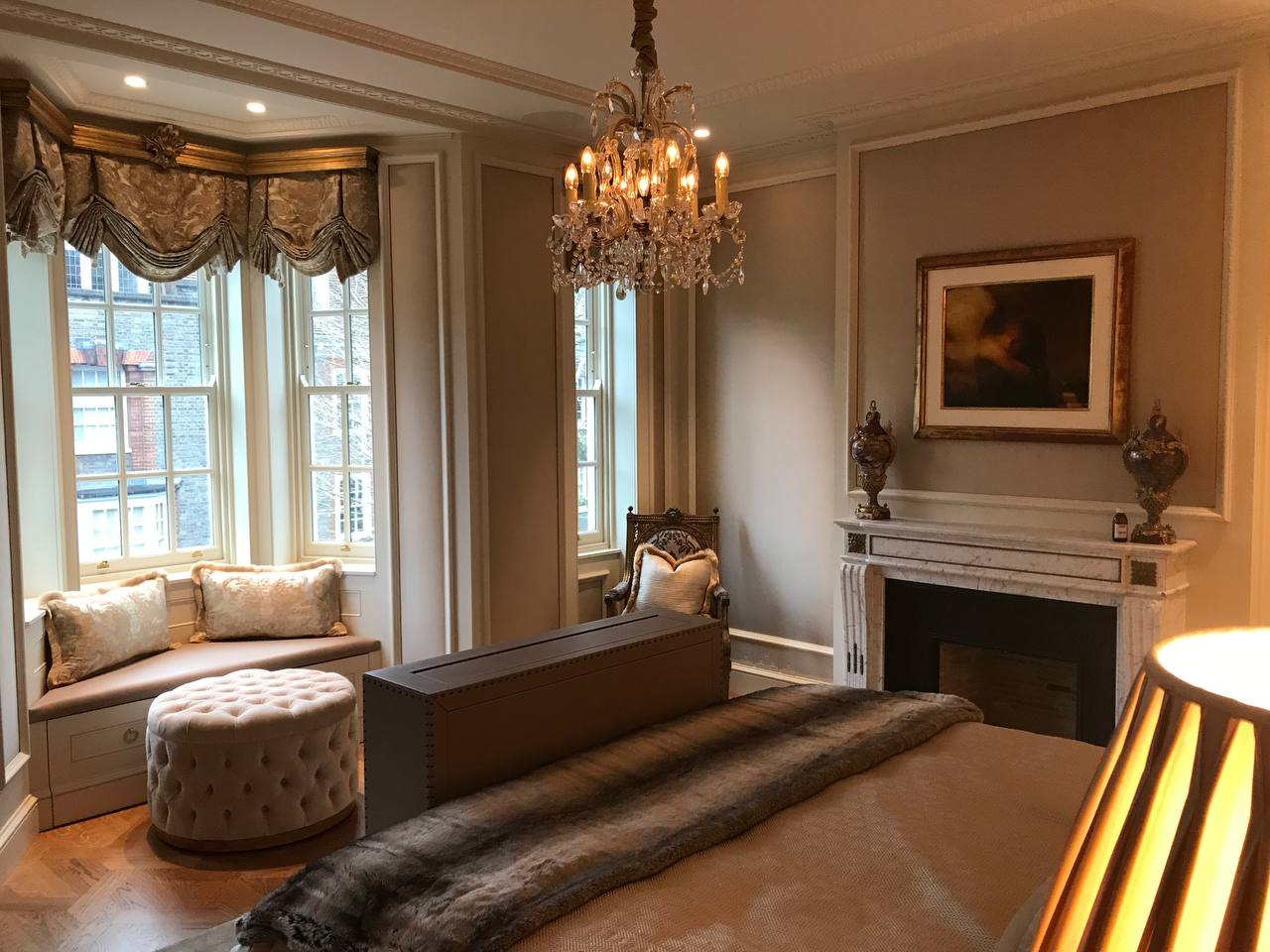 Master bedroom — crystal chandelier, bay window seat, silk cushions, tufted ottoman