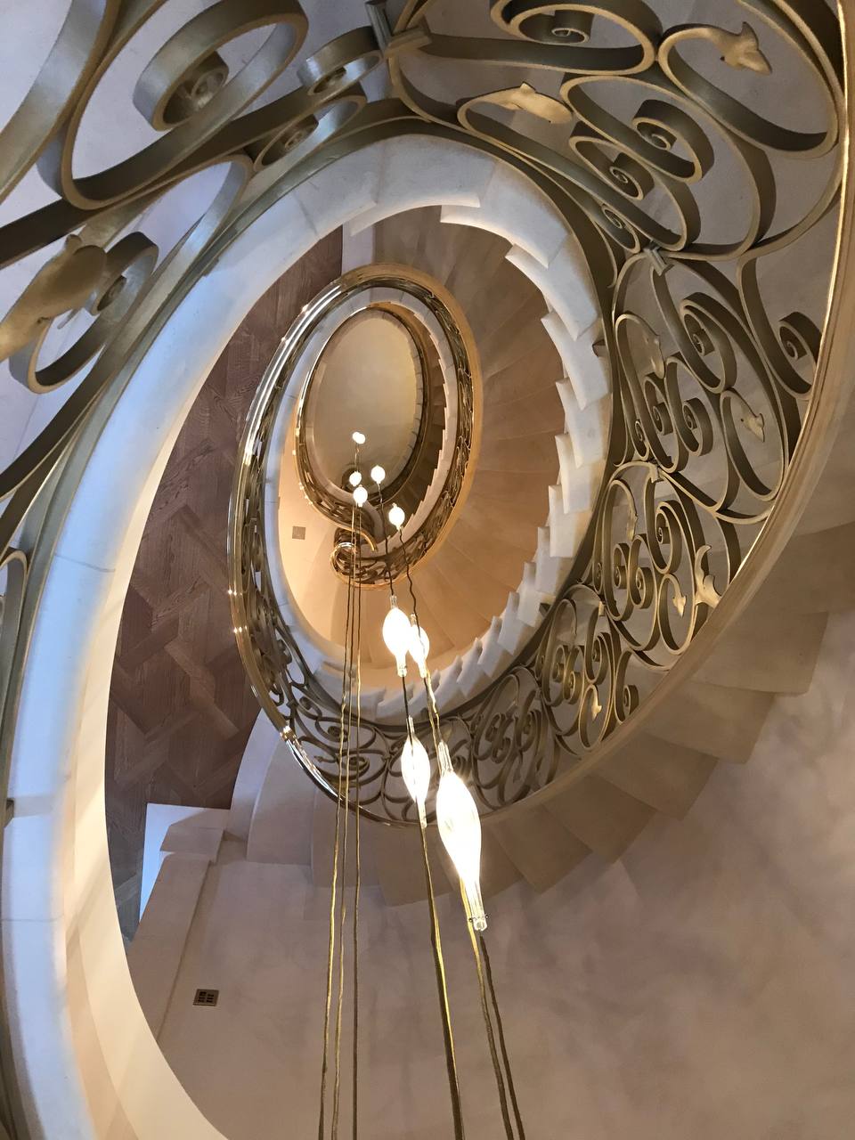 Spiral staircase from above — bespoke gold balustrade