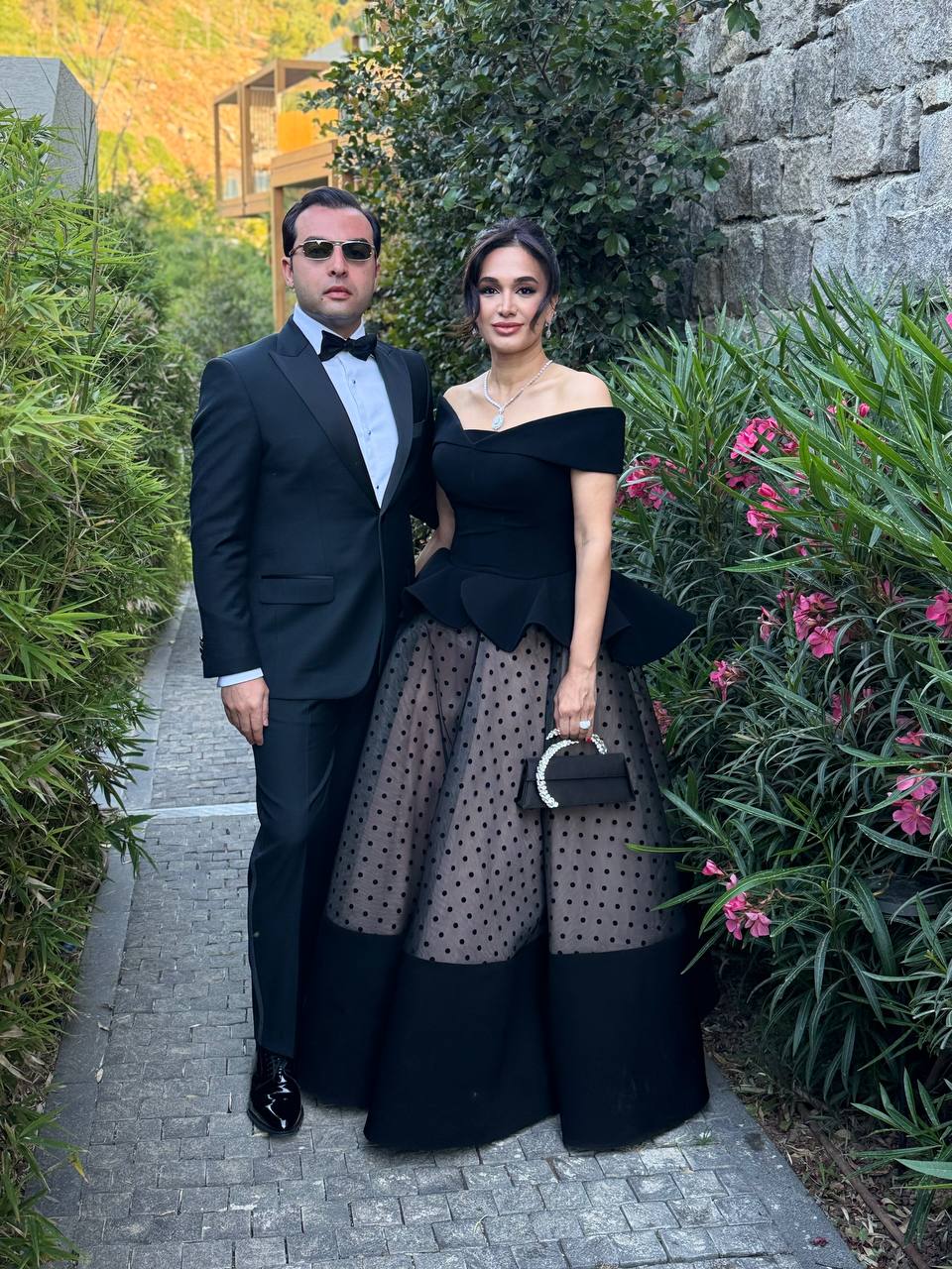 Saied Nazemi and wife at a friend's wedding, black tie, garden setting, Dubai 2025