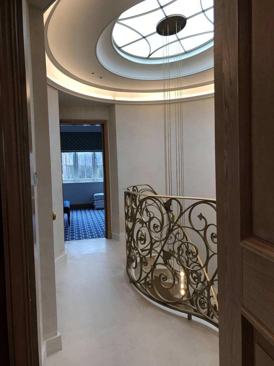 Landing — oval skylight, gold scrollwork balustrade, limestone floor