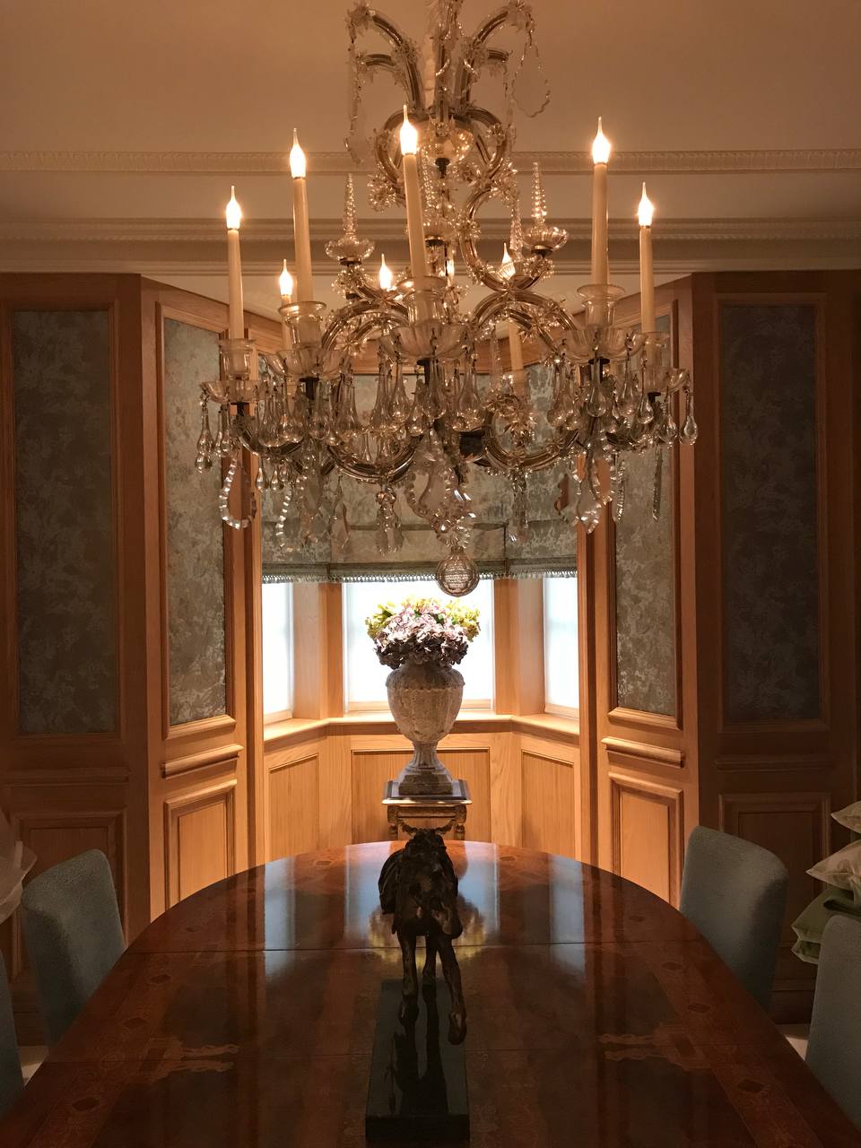Dining room — crystal chandelier, oak panelling, inlaid round table