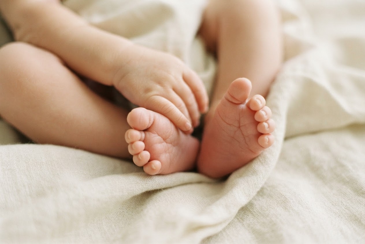 Newborn hands on linen