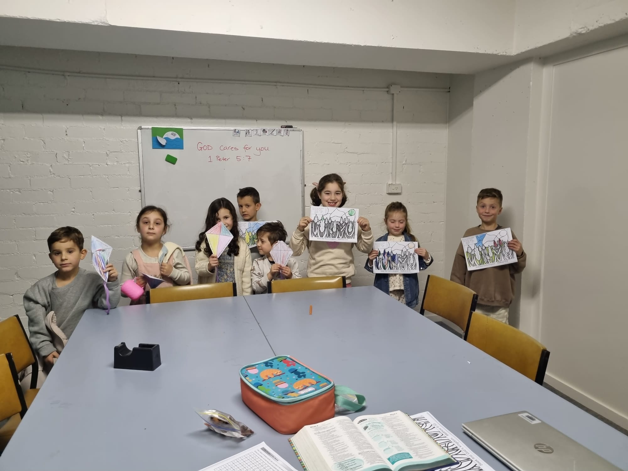 Children holding Bible artwork