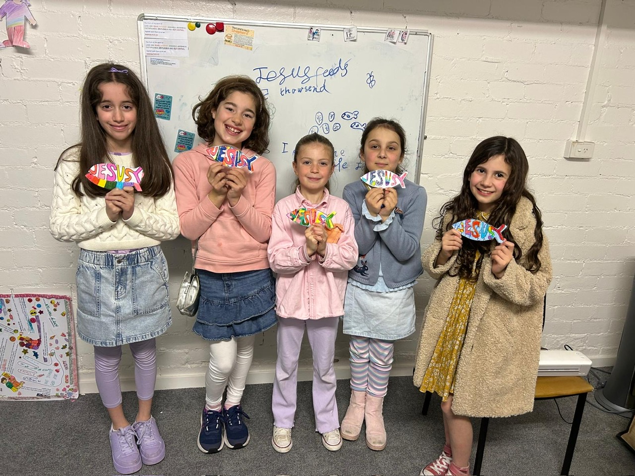 Children holding Jesus fish crafts