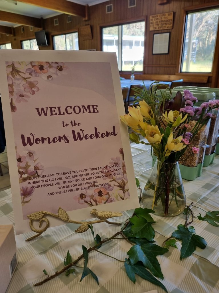 Welcome to the Women's Weekend sign with flowers