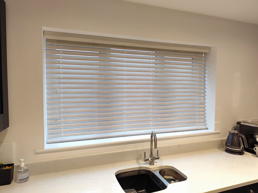 Wood-grain Venetian blinds fitted over a kitchen sink in Leeds