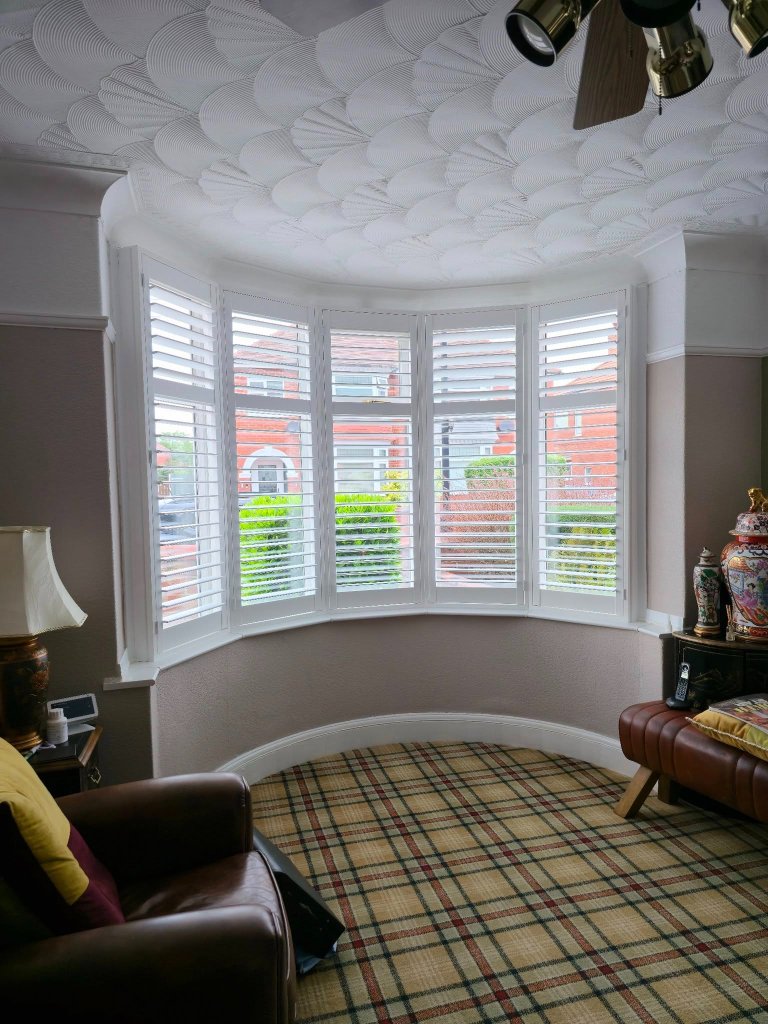 Plantation shutters fitted in a curved bay window Yorkshire living room