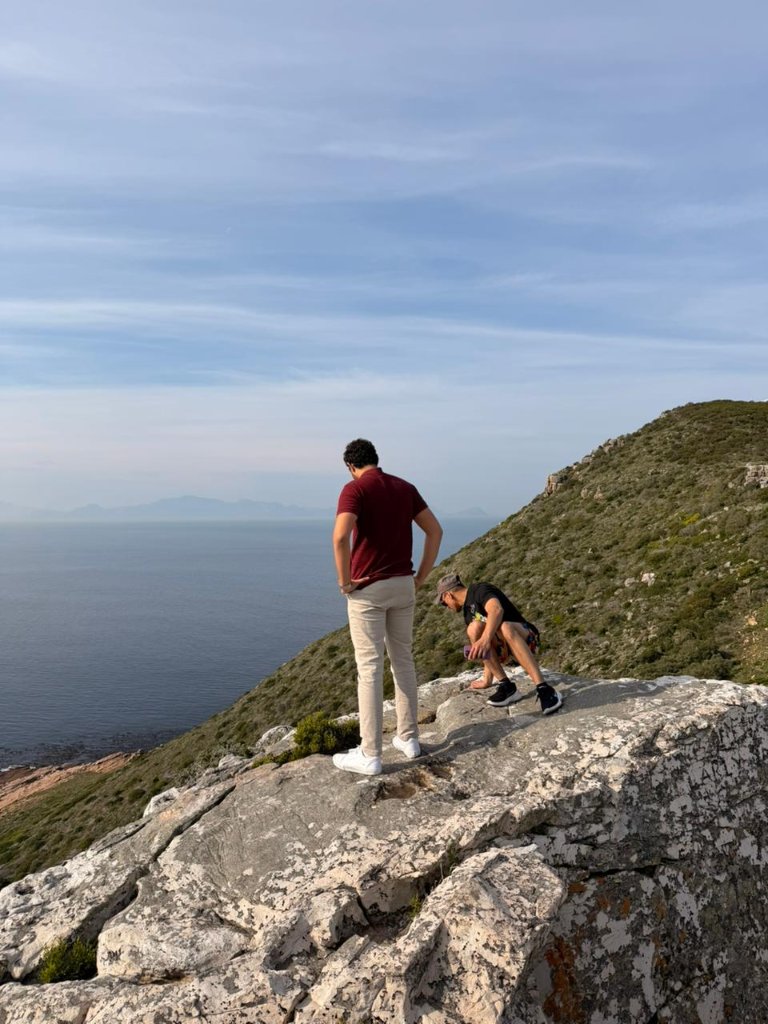 Guests on a rock overlooking the ocean