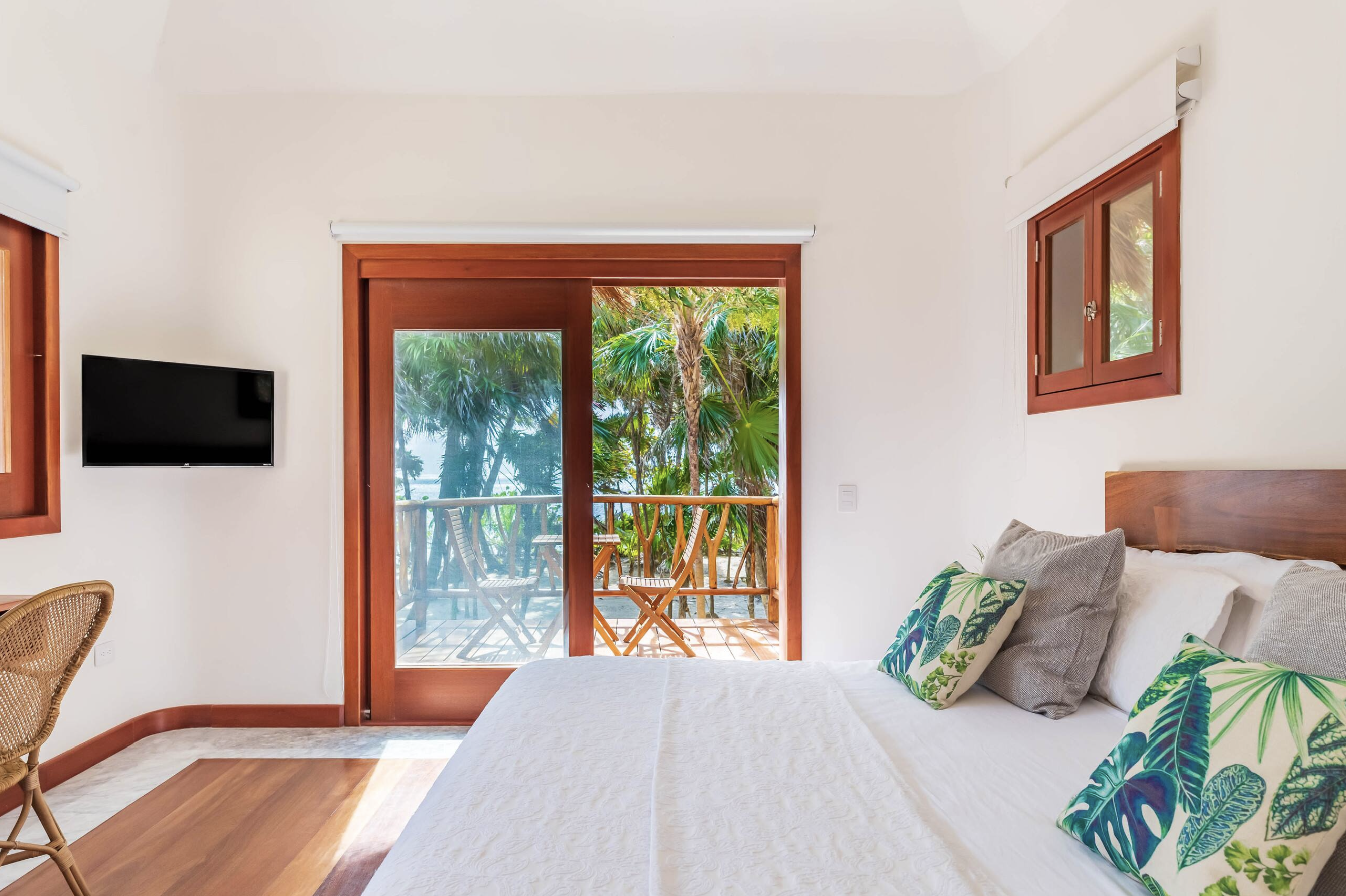 Bedroom with palm-leaf pillows & balcony