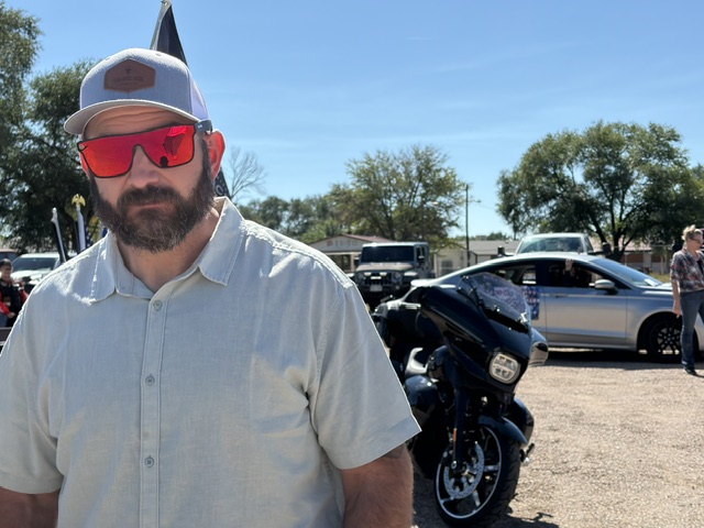 Avondale Veteran's Parade — bearded rider with red sunglasses by motorcycle