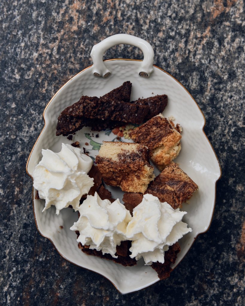 Tallerken med chokoladekage, småkager og flødeskum