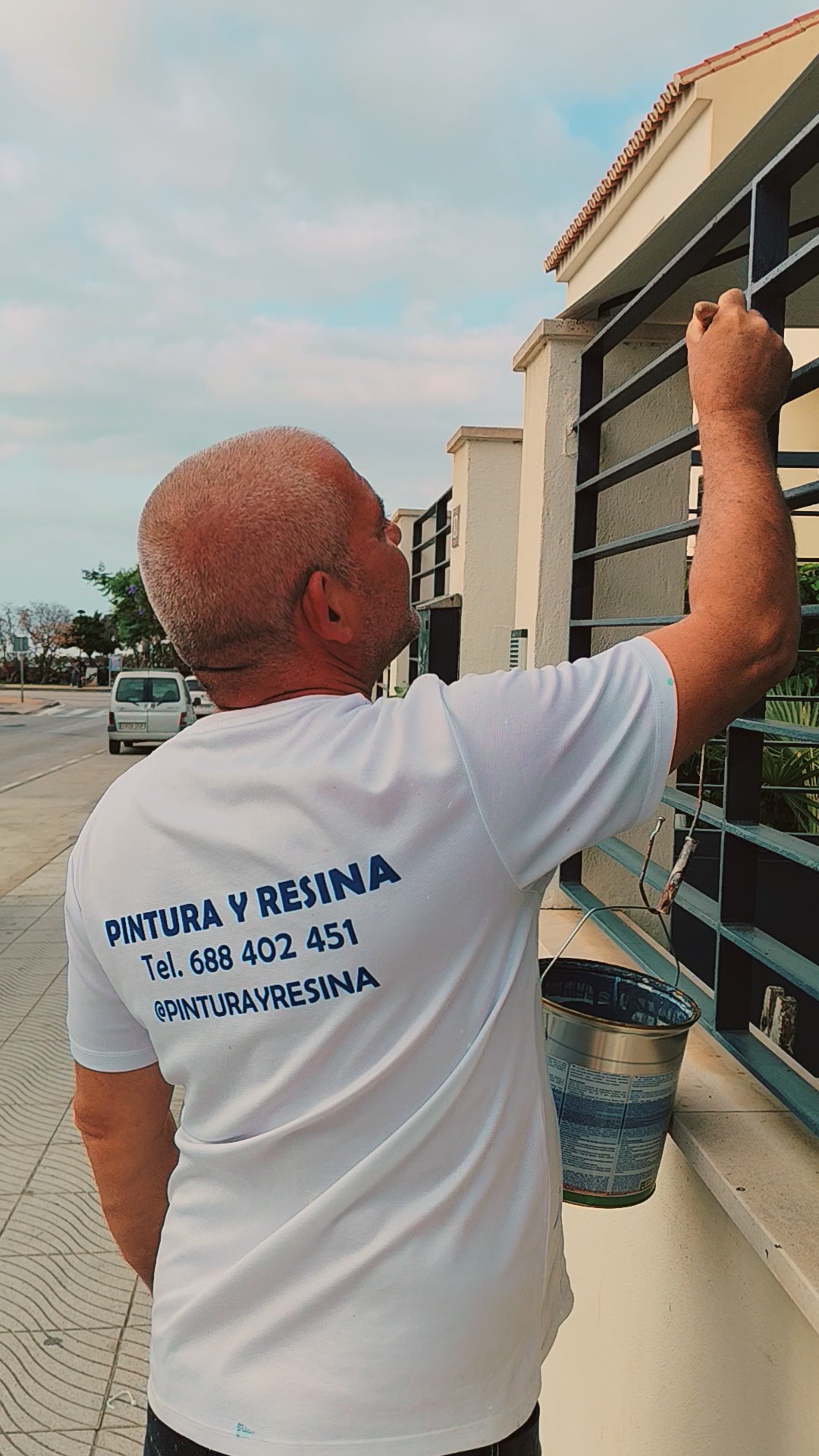 Profesional de Pintura y Resina pintando una reja metálica en la Axarquía