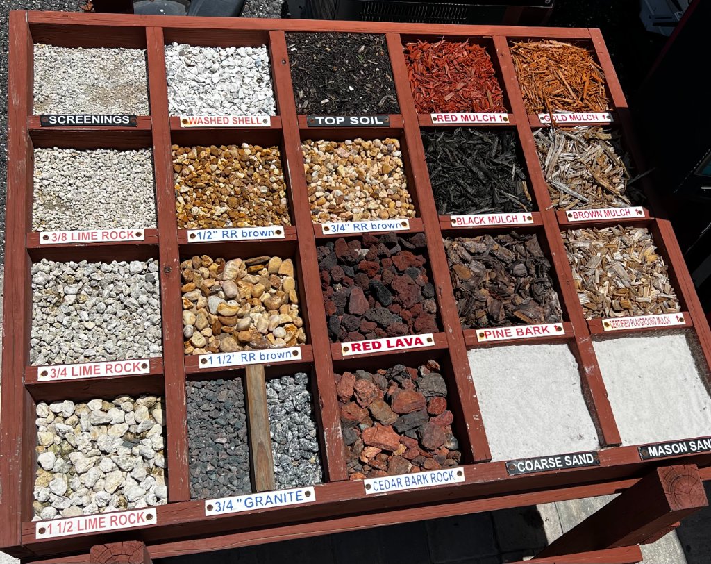 Rogers Landscape Supply materials display bin showing mulch, rock, sand, shell, and more