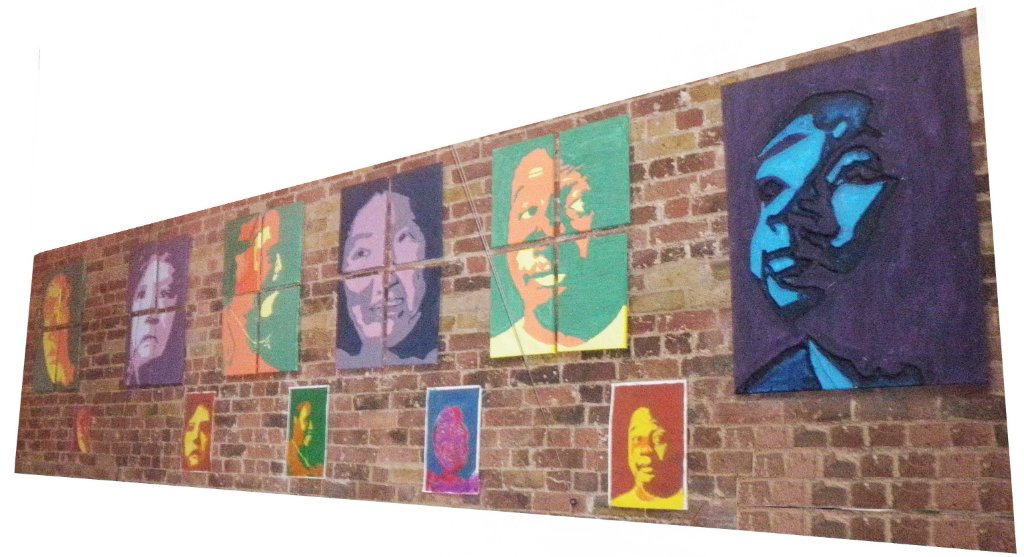 Colourful portrait artwork displayed on a brick wall at Mencap