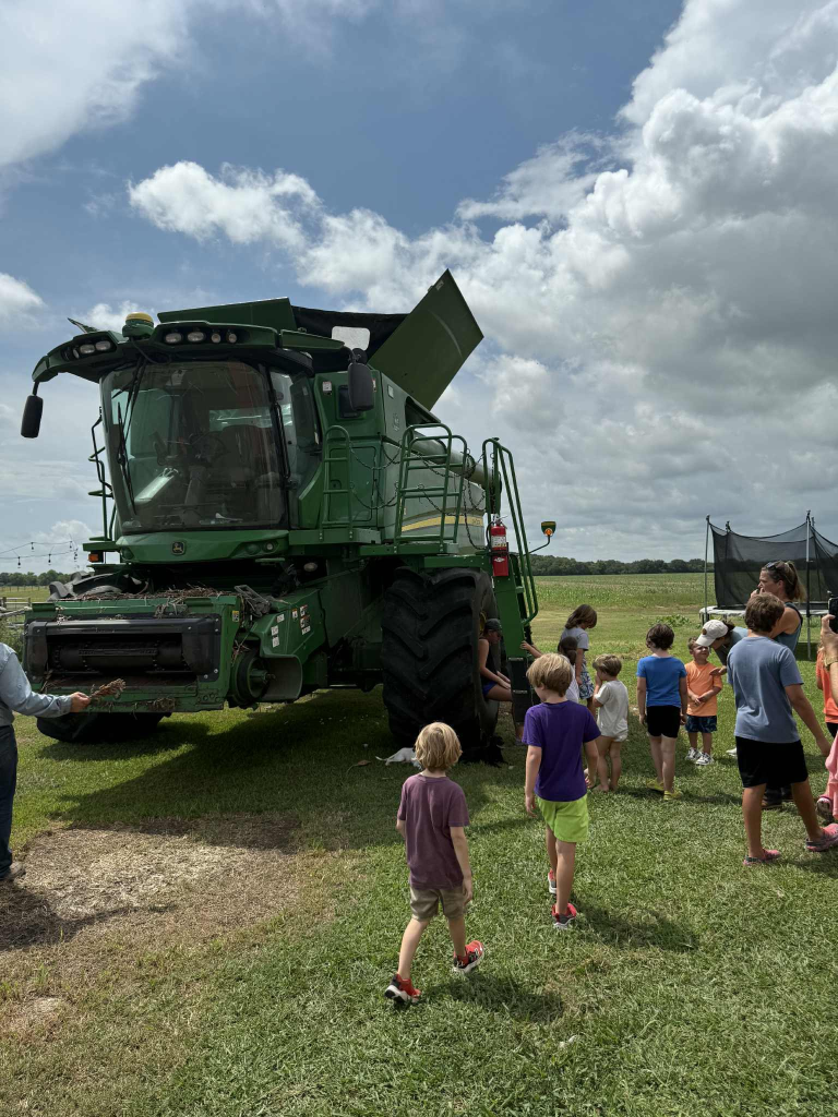 Kids exploring a John Deere combine harvester