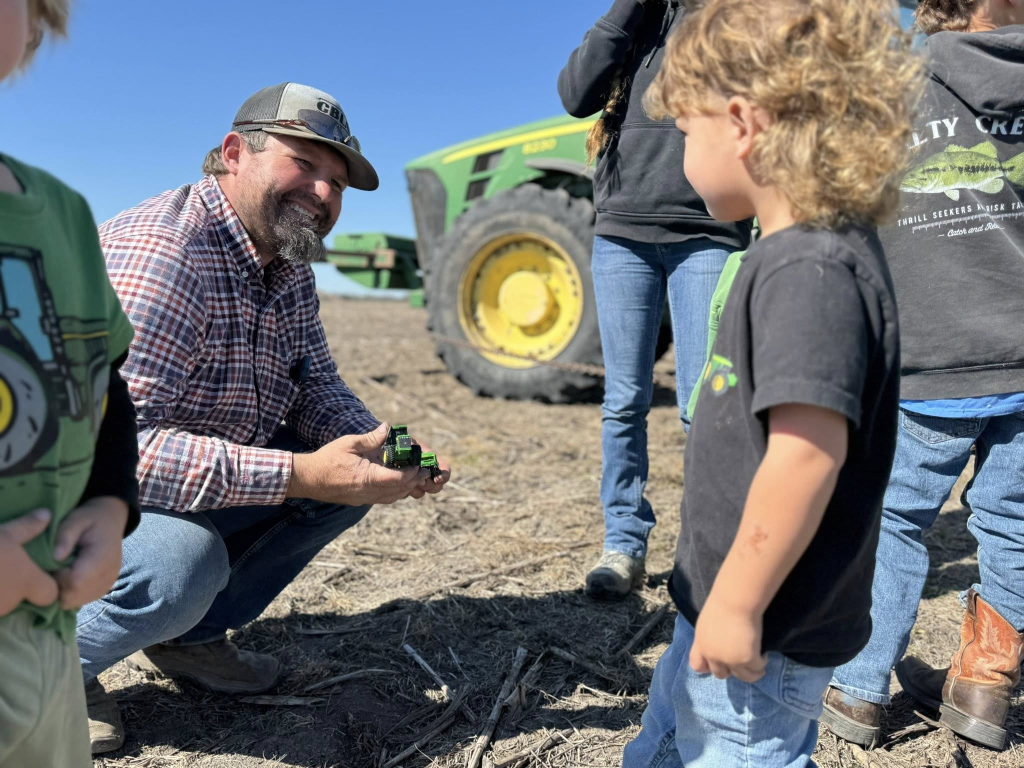 Farmer showing toy tractor to a child