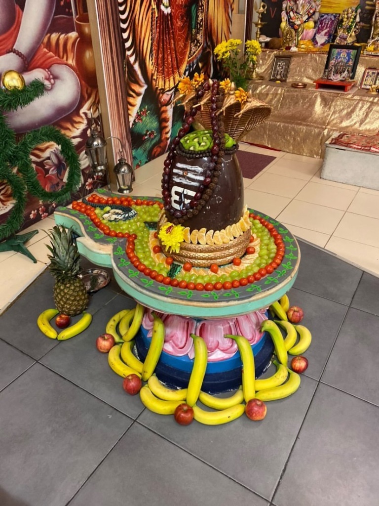 A vibrant fruit shringar of grapes, oranges, bananas and pineapple.