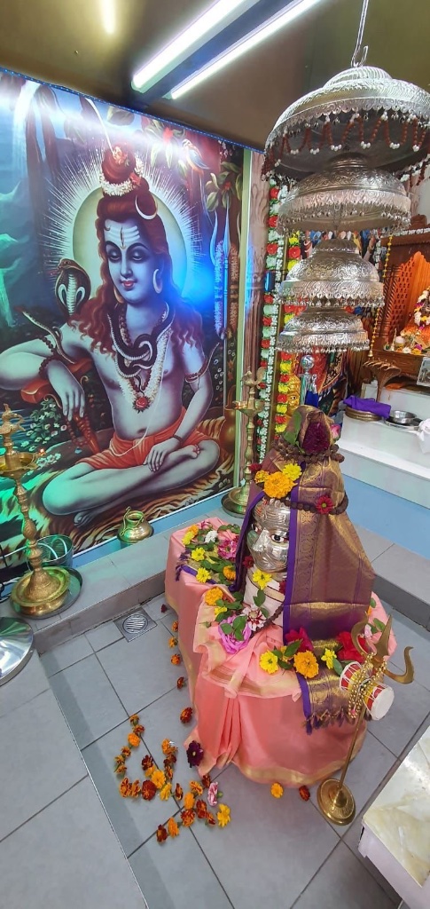 Evening darshan of the Lingam dressed in silk and marigold garlands.