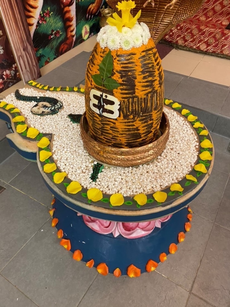 A tiger-stripe shringar set upon a bed of puffed rice and flower petals.