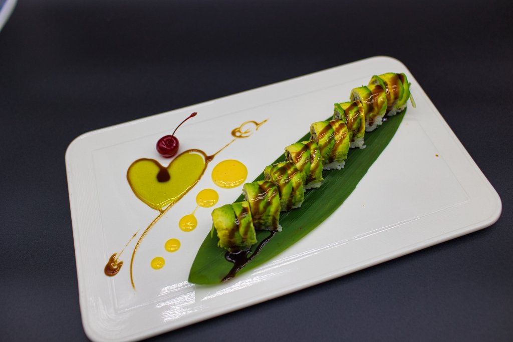 Sushi rolls on banana leaf with heart-shaped mango sauce