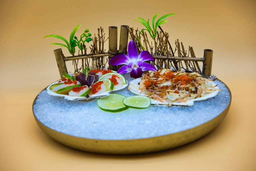 Scallop sashimi on ice with bamboo fence decoration