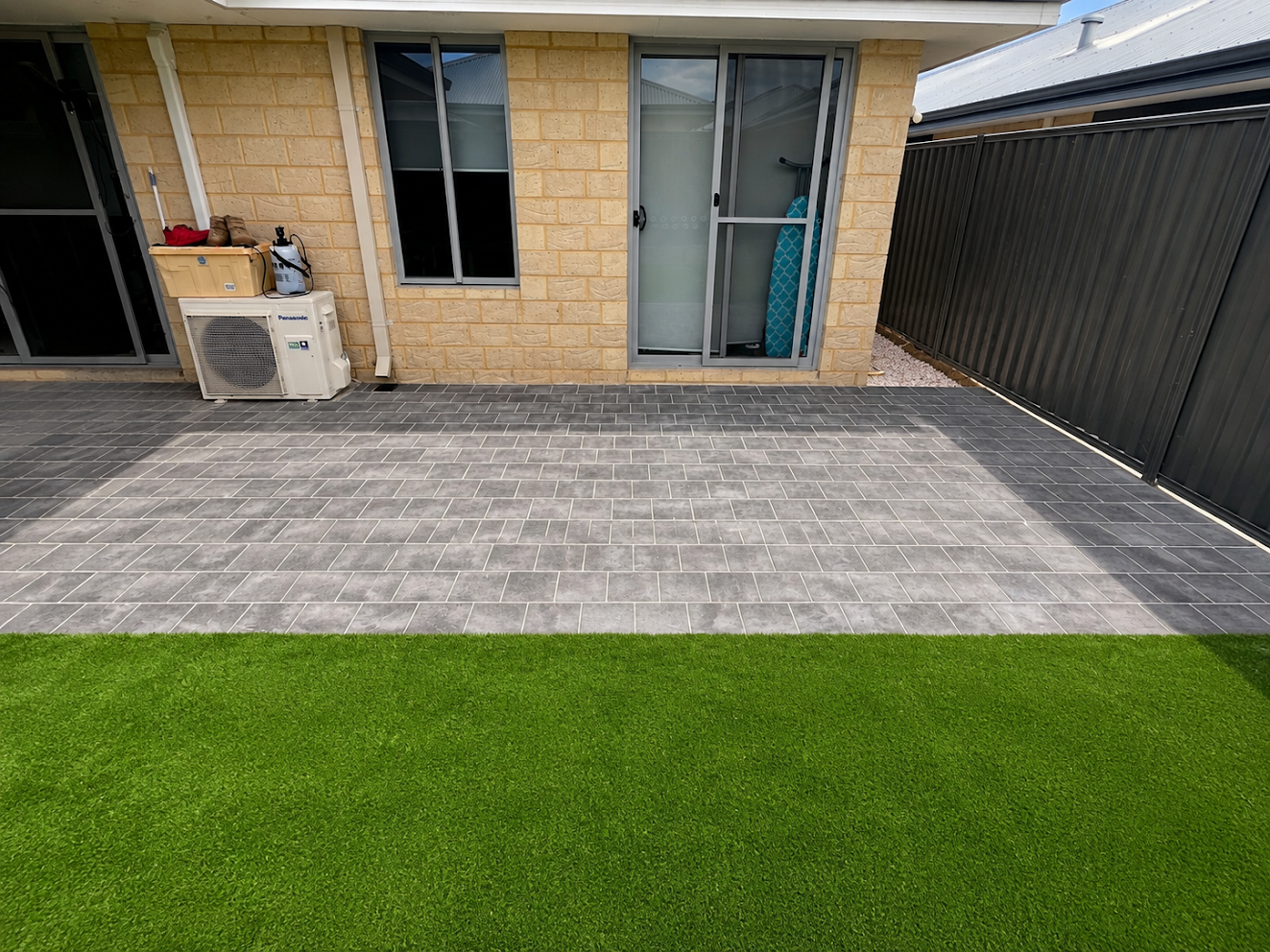 New turf meeting a two-tone paved patio