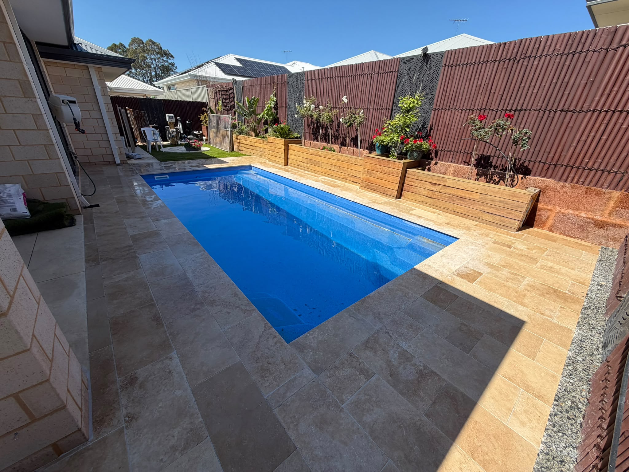 Paved pool surround with timber planter box