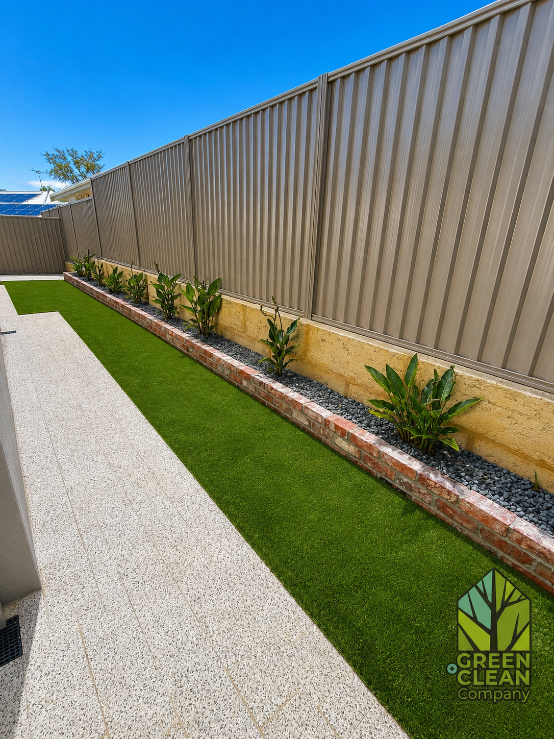 Side yard with limestone retaining wall and artificial turf