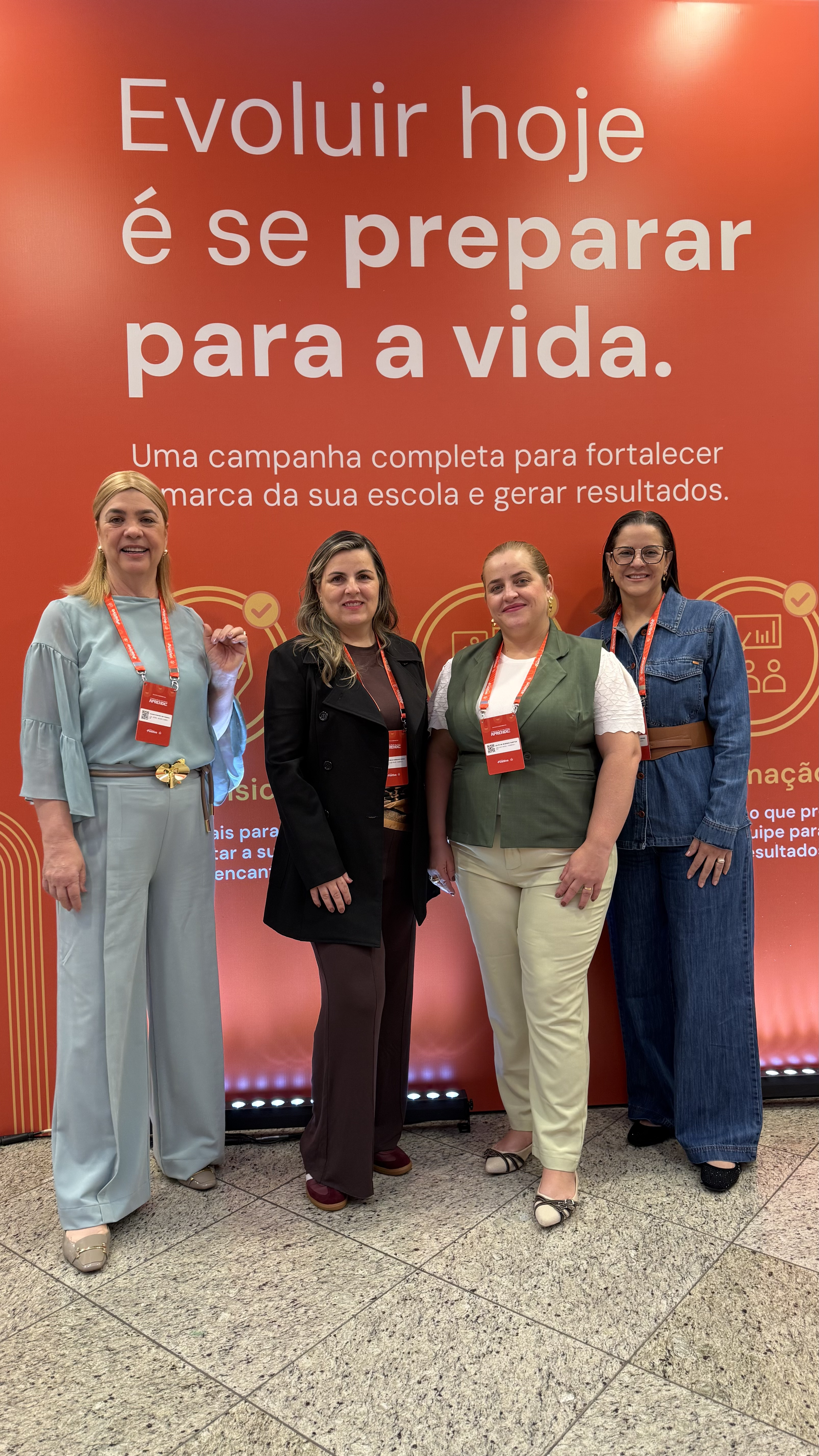 Equipe do Colégio Visão em frente ao painel do Sistema Positivo de Ensino