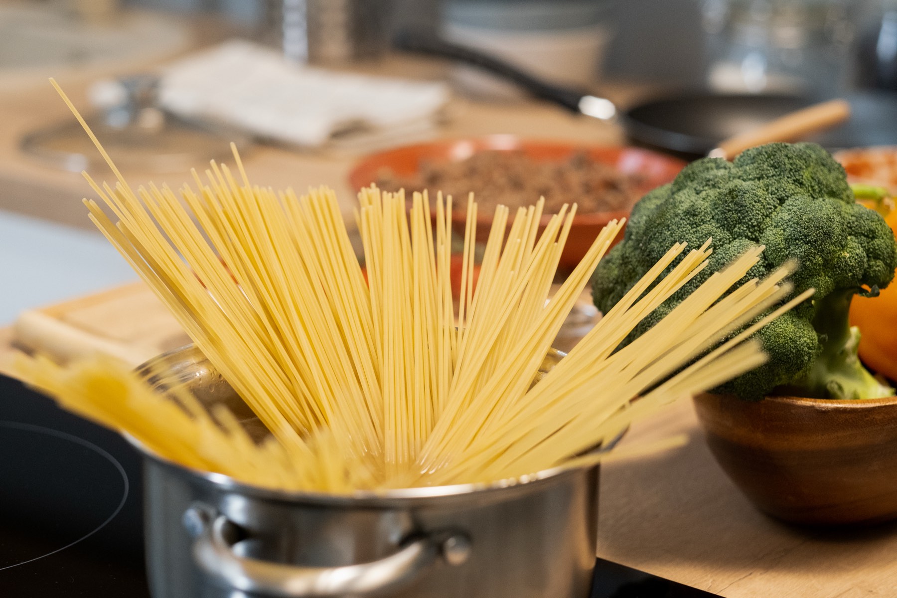 Fresh spaghetti and vegetables on a restaurant counter