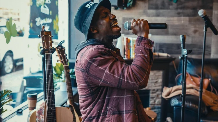 Saturday Sanctuary — musician performing into a microphone during a worship night