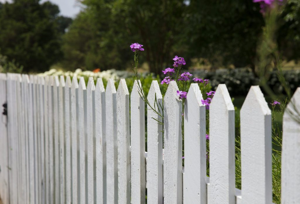 White picket fence with flowers in a residential yard