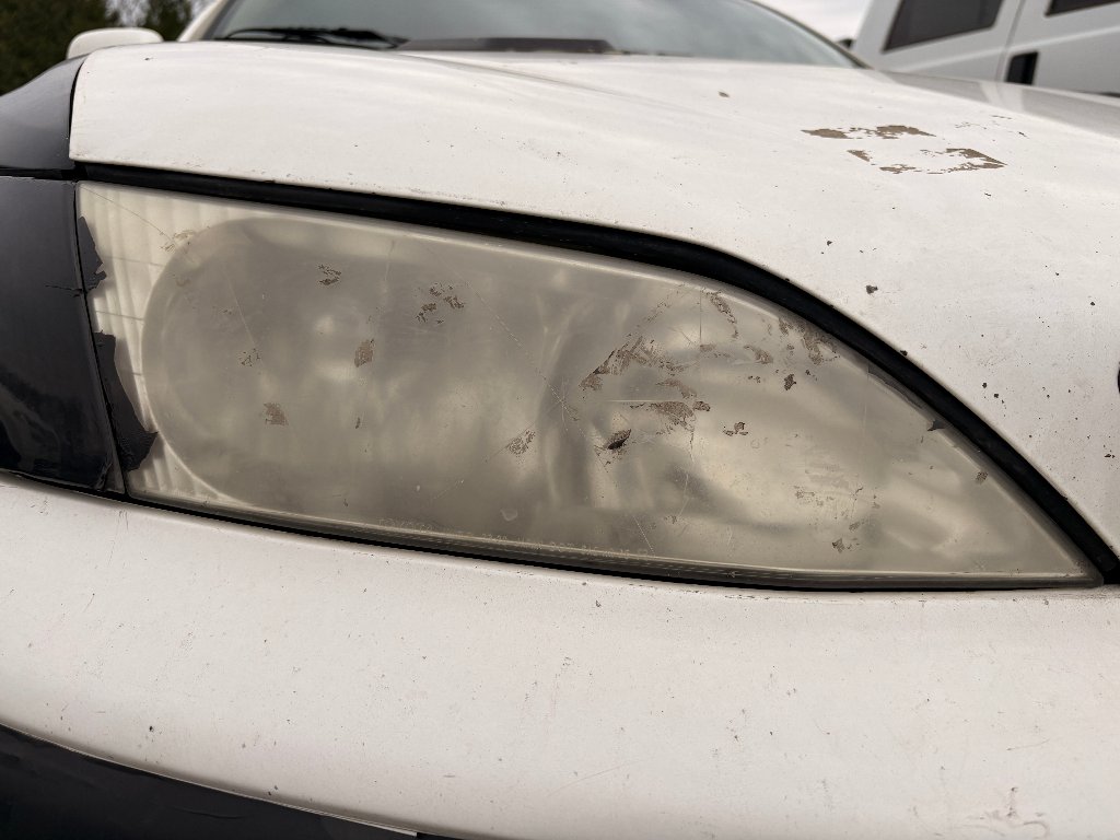 Lexus headlight before restoration — foggy, oxidized, yellowed headlight lens in Hillsboro, OR
