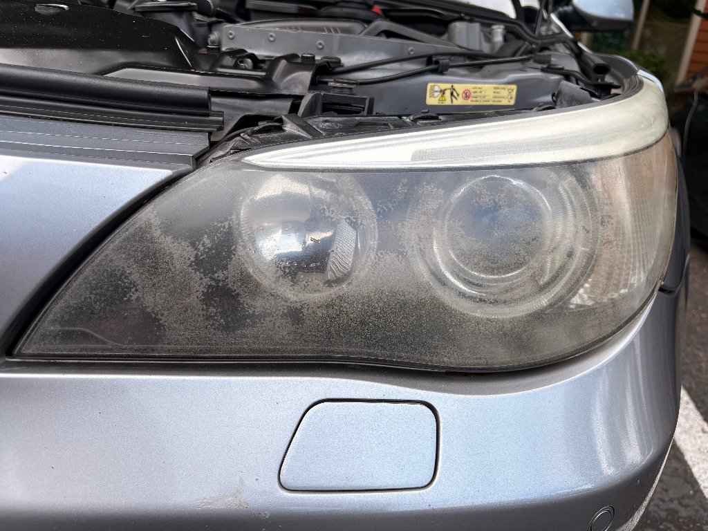 BMW 5 Series headlight before restoration — foggy, oxidized, yellowed headlight lens in Beaverton, OR