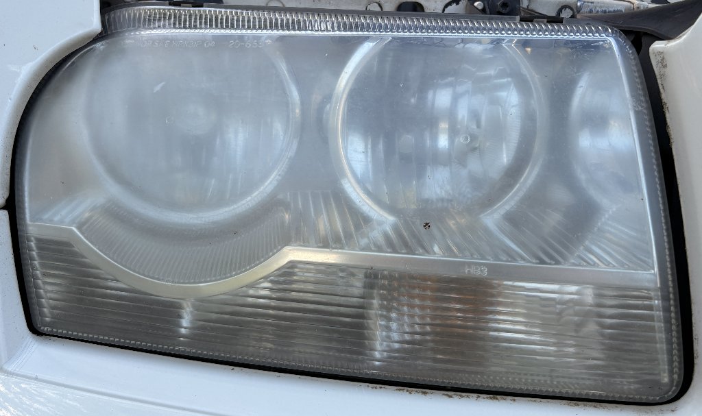 Cadillac headlight before restoration — foggy, oxidized, yellowed headlight lens in Gresham, OR