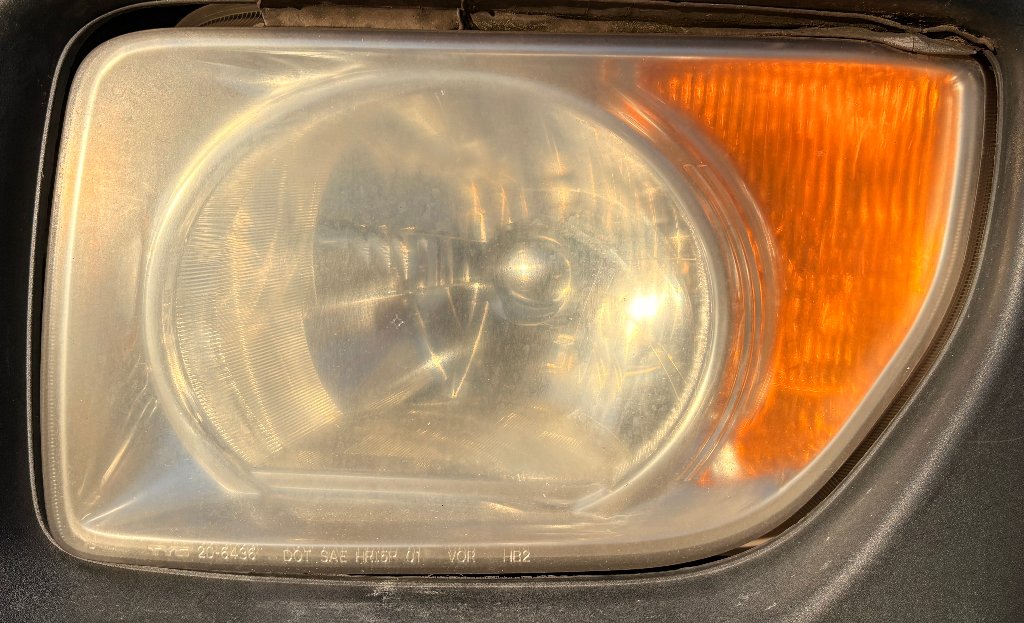 Honda Element headlight before restoration — foggy, oxidized, yellowed headlight lens in Portland, OR