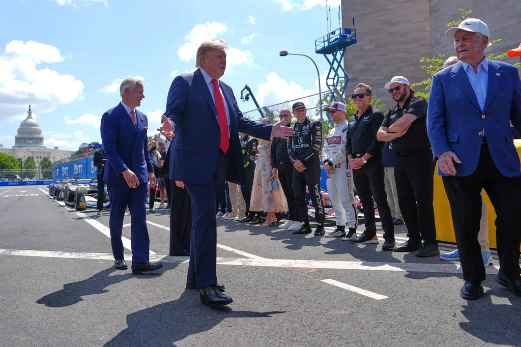 President Donald Trump gestures while speaking with IndyCar drivers on the Freedom 250 track
