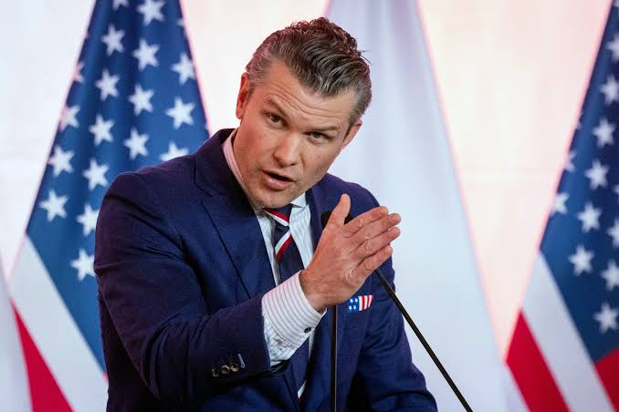 Pete Hegseth speaking at a podium