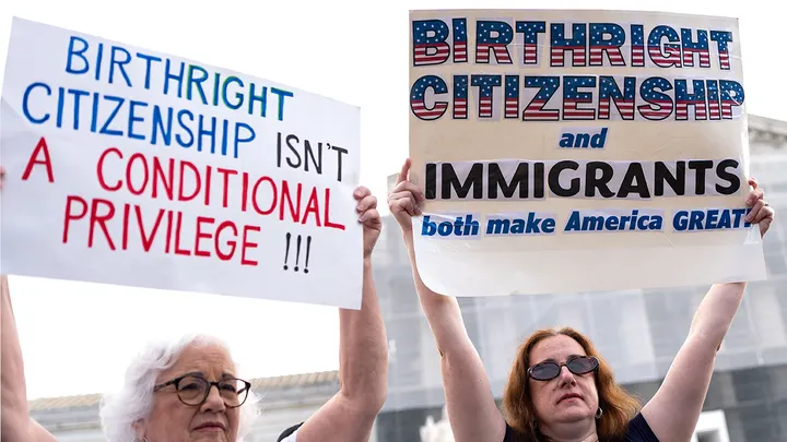 Protesters outside the Supreme Court holding signs defending birthright citizenship