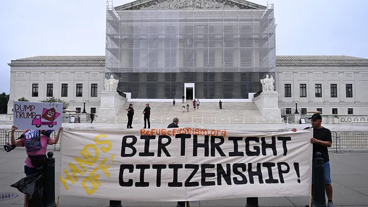 Demonstrators with a 'Hands Off Birthright Citizenship' banner on the Supreme Court plaza