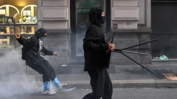 Masked protesters amid tear gas in Milan