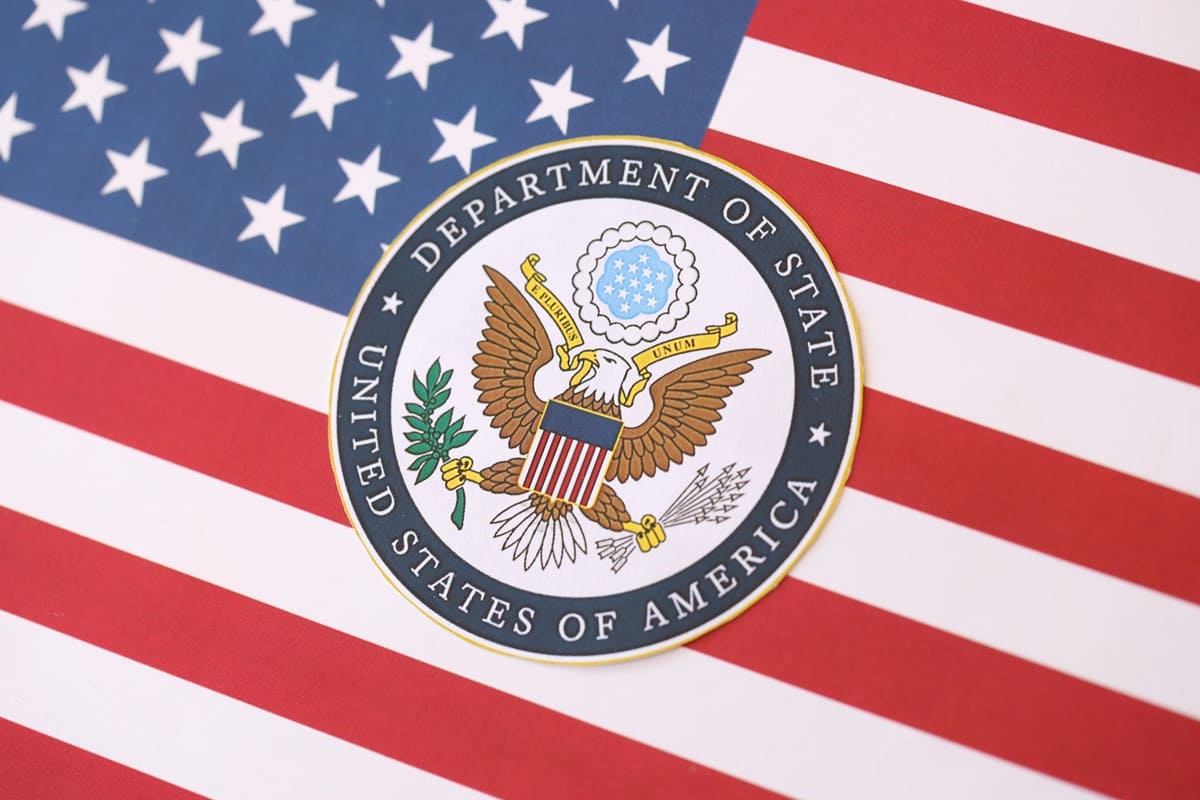 Seal of the U.S. Department of State over an American flag background