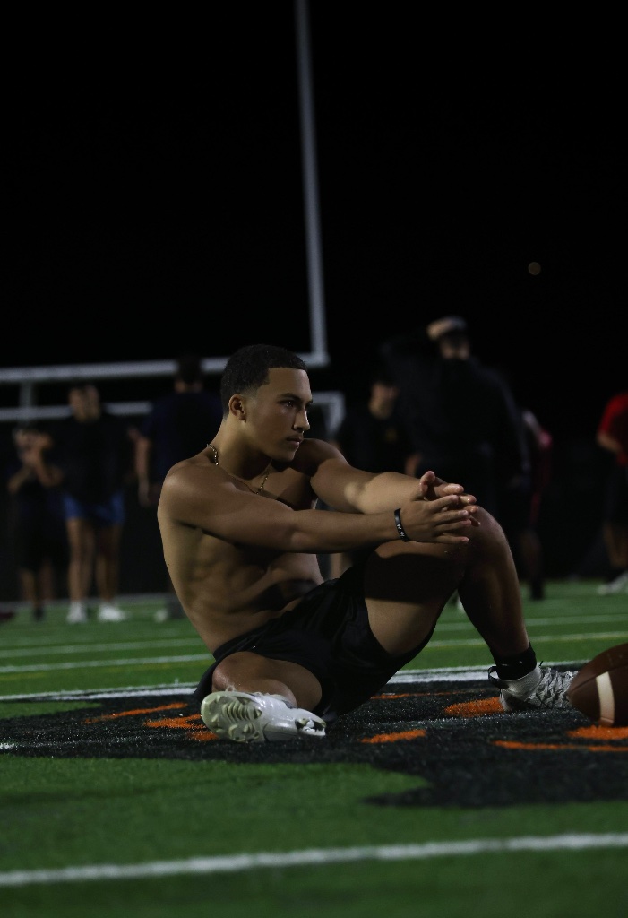 Football athlete sitting on the turf at night