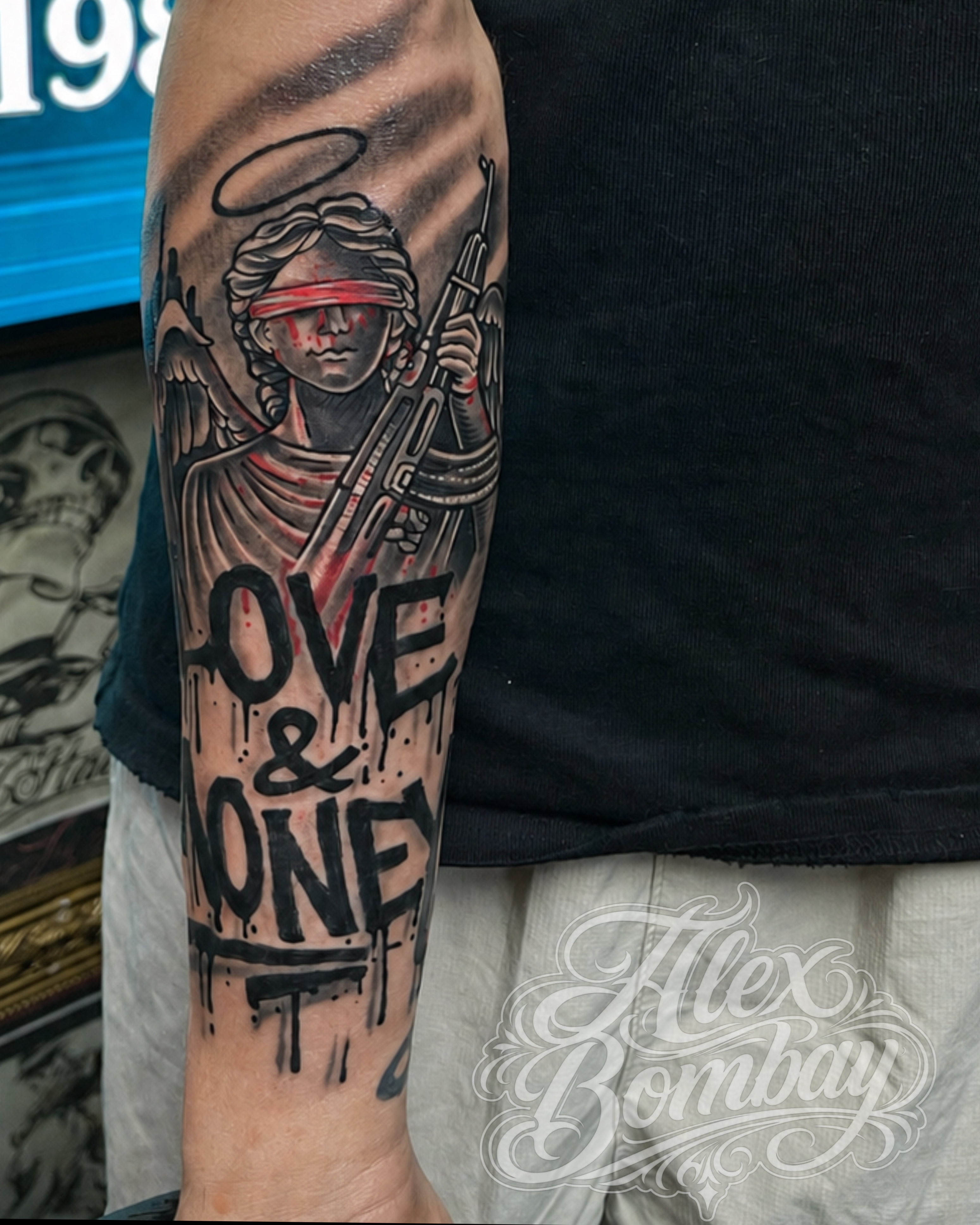 Blindfolded angel of death with rifle and Love and Money graffiti script forearm tattoo for men black and grey realism by Alex Bombay — Tattoo Mania Studio Athlone Ireland | Athlone Tattoo Studio / Tattooing By Alex Bombay — Keeping The World Colorful Since 1982