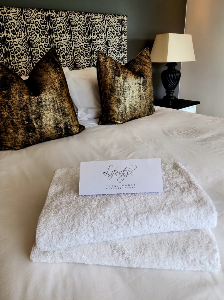 Luxury white towels rolled on stone surface with warm spa lighting